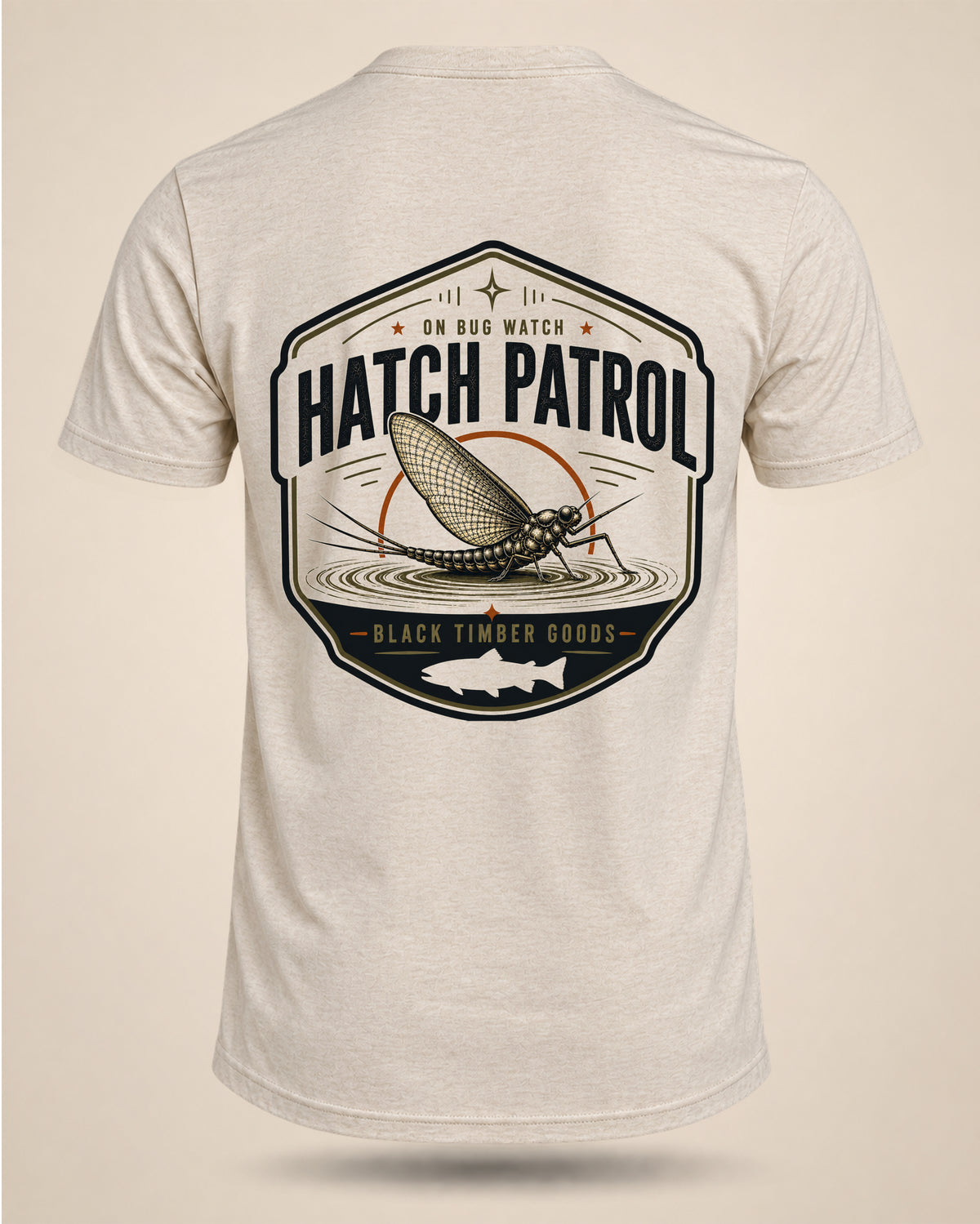 Cream Hatch Patrol fly-fishing T-shirt featuring a large mayfly badge with On Bug Watch text and Black Timber Goods branding.