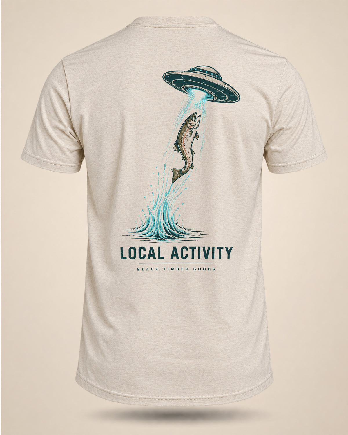 Cream Local Activity fishing T-shirt featuring a rising trout beneath a hovering UFO with a beam shining toward the water.
