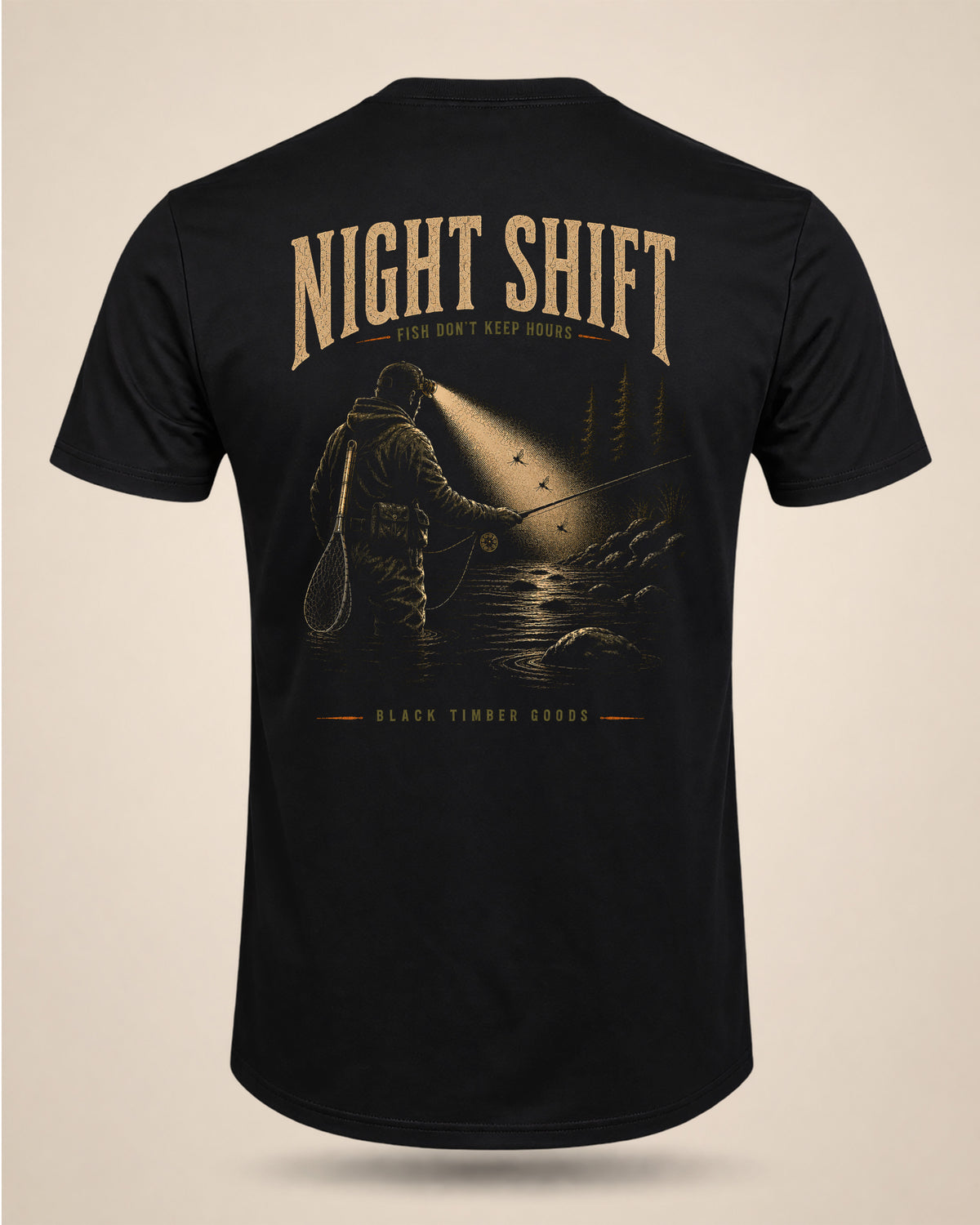 Black Night Shift T-shirt featuring a nighttime fly-fishing scene with an angler in a headlamp beam and the text Night Shift Fish Don’t Keep Hours.