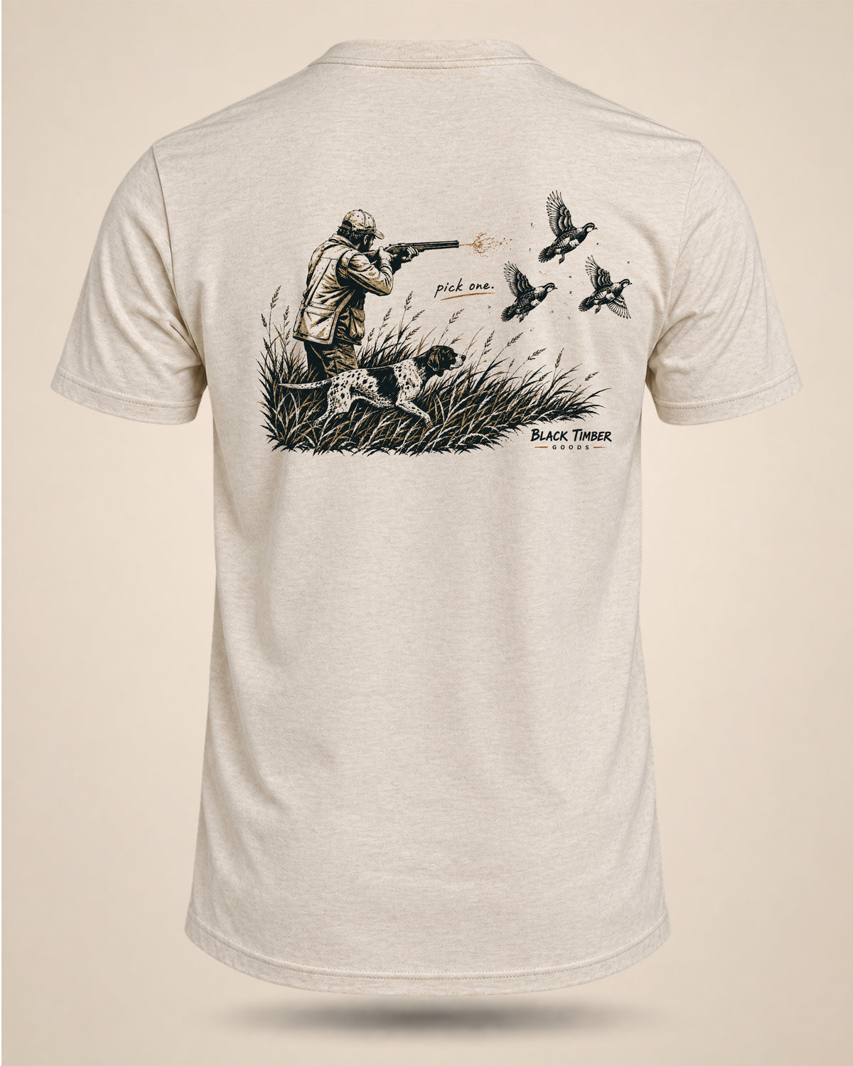 Cream Pick One upland hunting T-shirt featuring a hunter, bird dog, and flushing game birds in tall grass.
