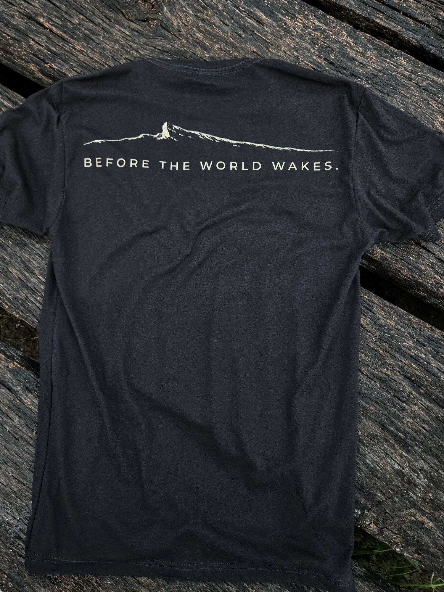 Before The World Wakes outdoor shirt by Black Timber Goods folded on weathered wood.