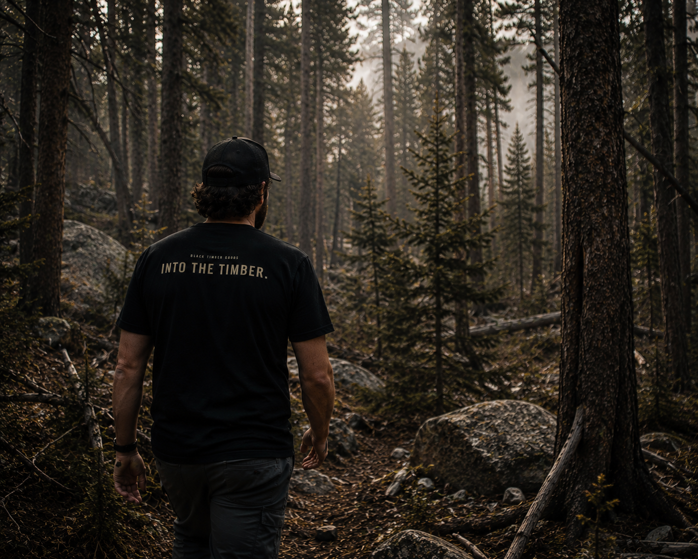Person wearing Into The Timber trail shirt by Black Timber Goods in the woods.