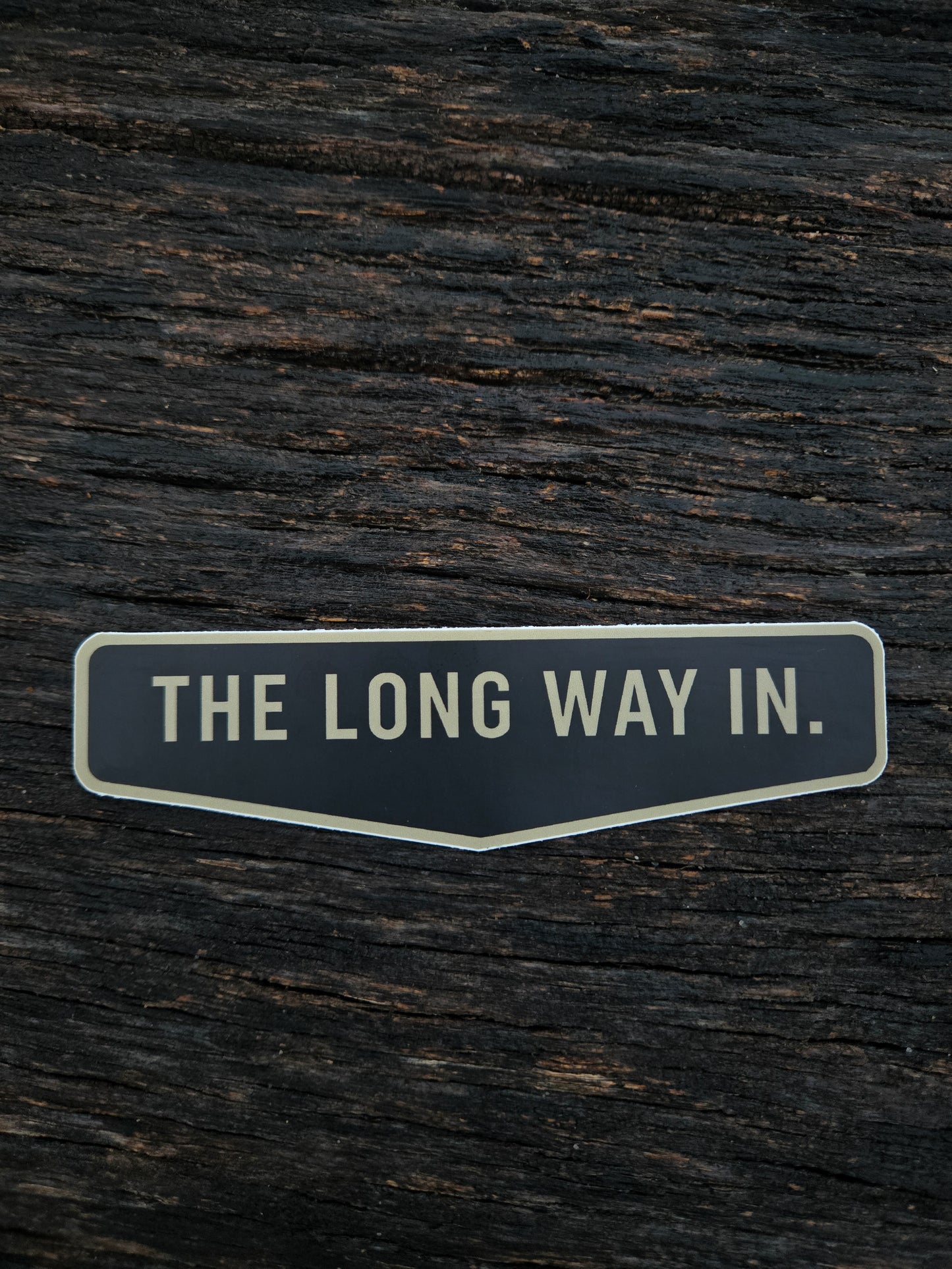The Long Way In waterproof vinyl sticker by Black Timber Goods on weathered wood.