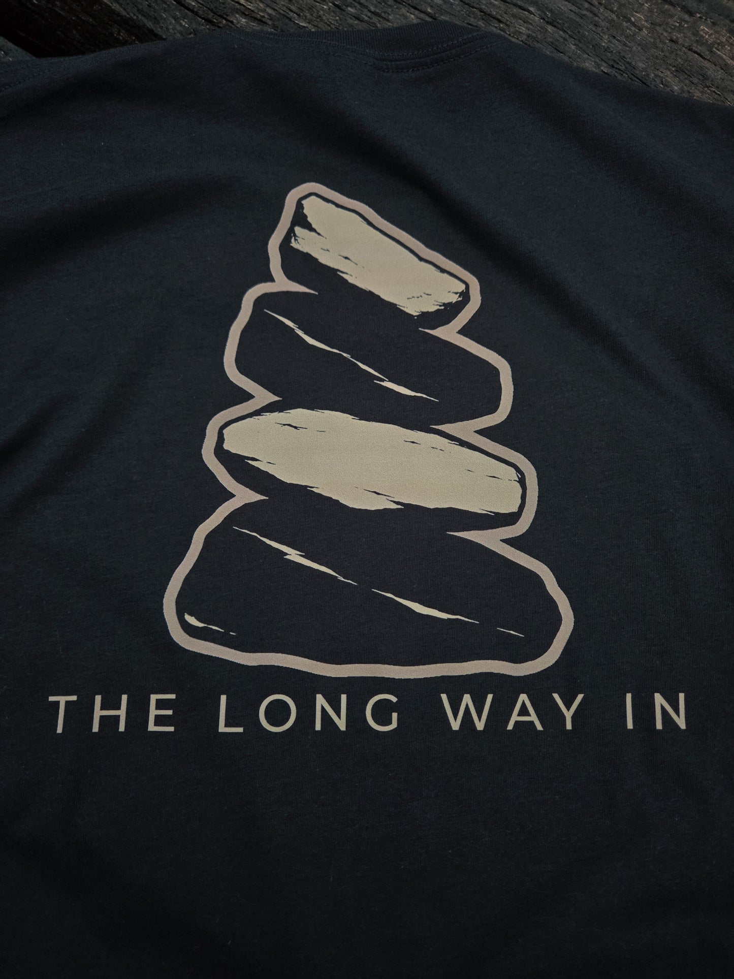 Close-up of The Long Way In weathered cairn artwork on the back of the shirt.